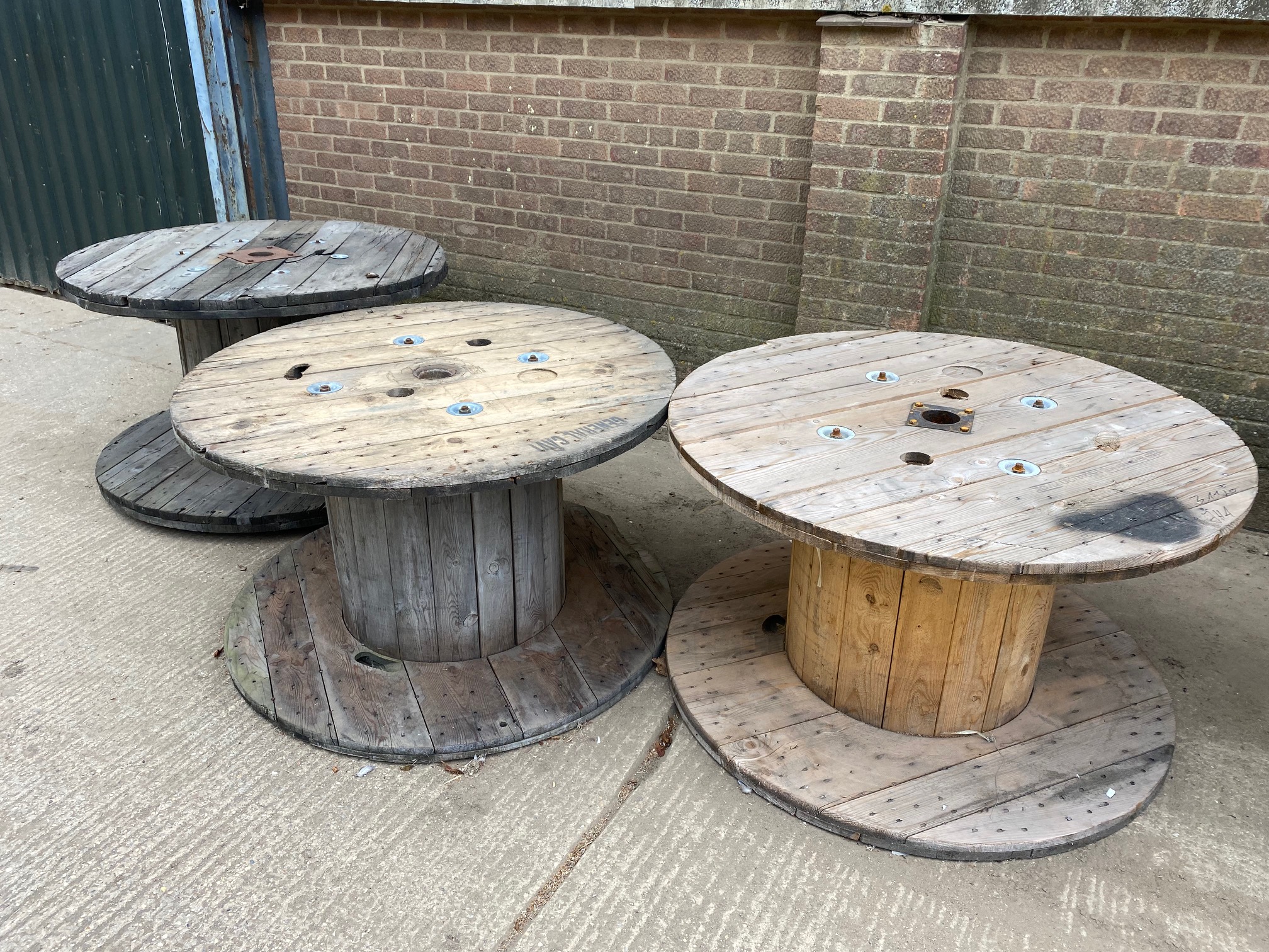 large wooden bobbins that can be used as garden tables.