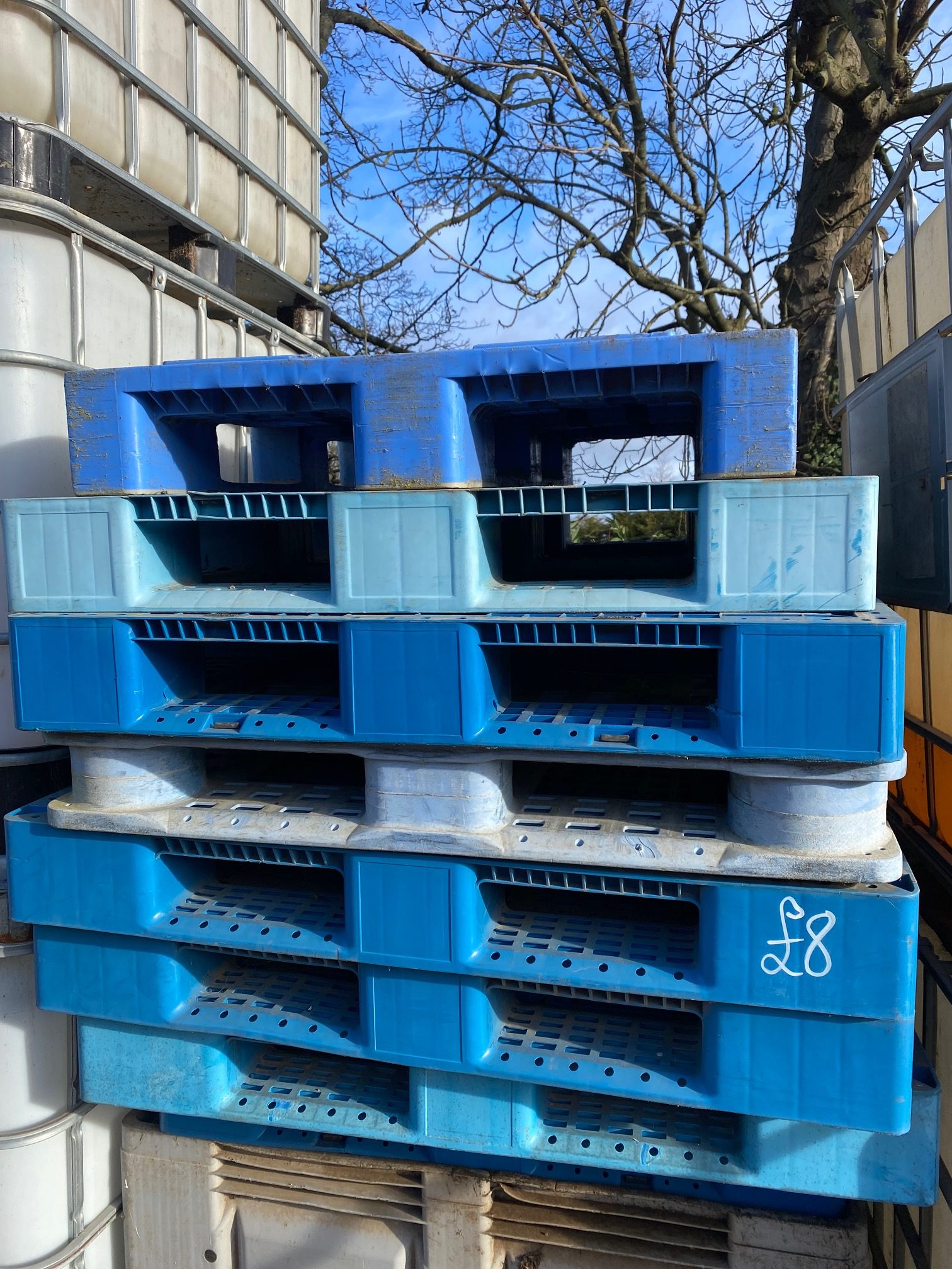 stack of blue and grey plastic pallets, stackable, sturdy 