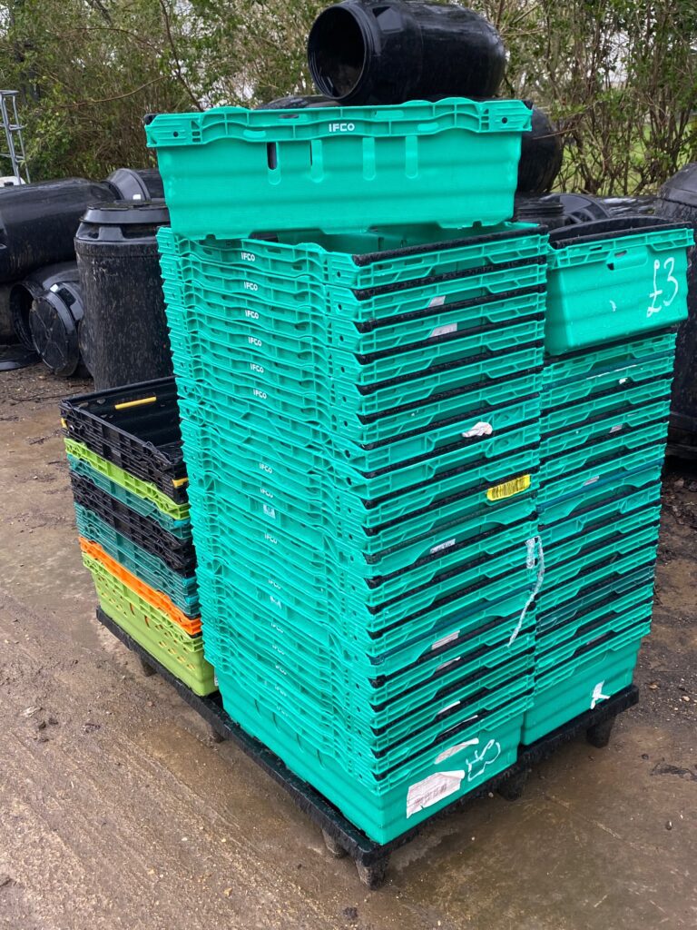 large stack of green and black stackable trays, sturdy, strong solid trays.